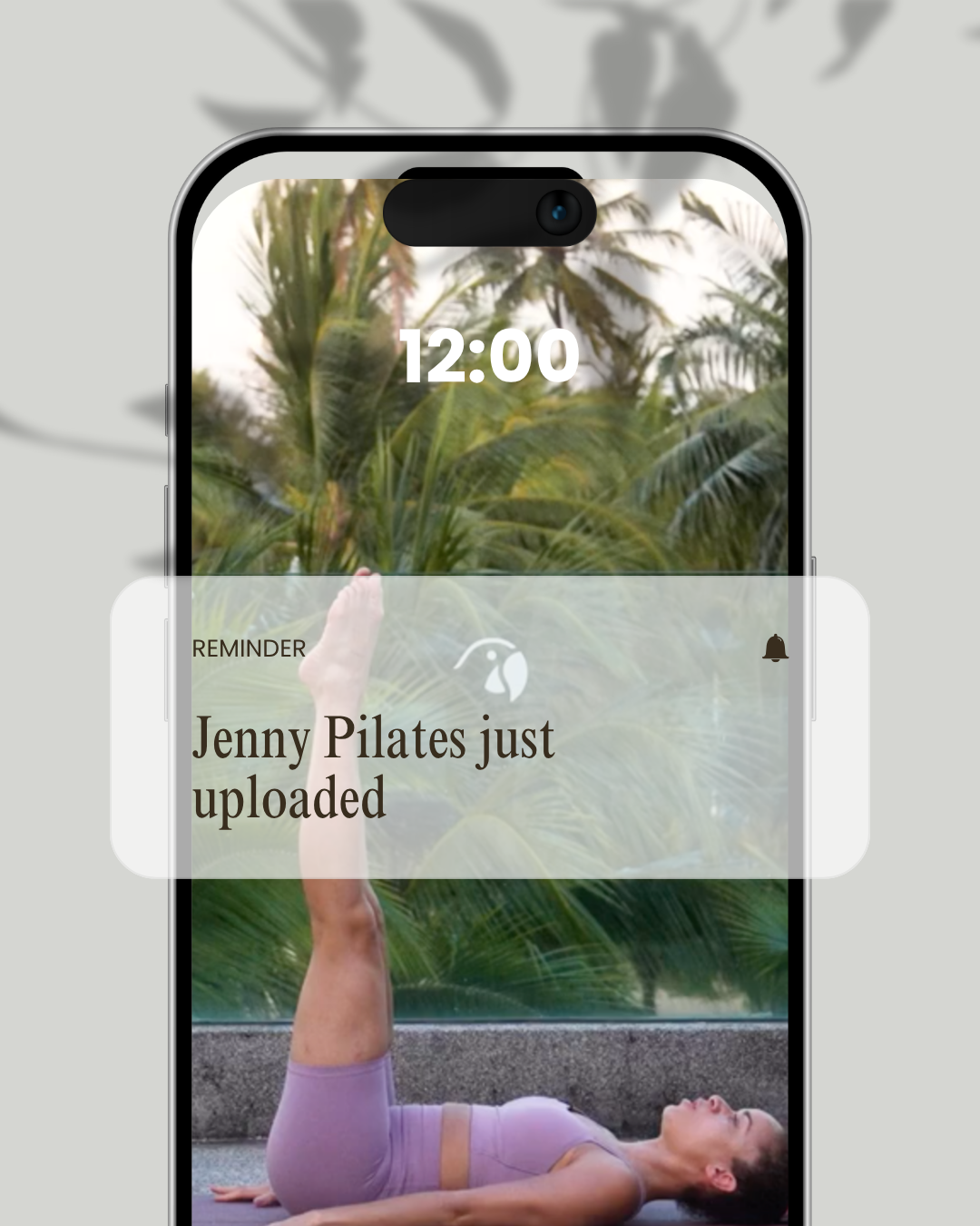 Smartphone-Display zeigt eine Benachrichtigung, dass „Jenny Pilates“ hochgeladen wurde, mit einem Hintergrundbild einer Frau beim Pilates.