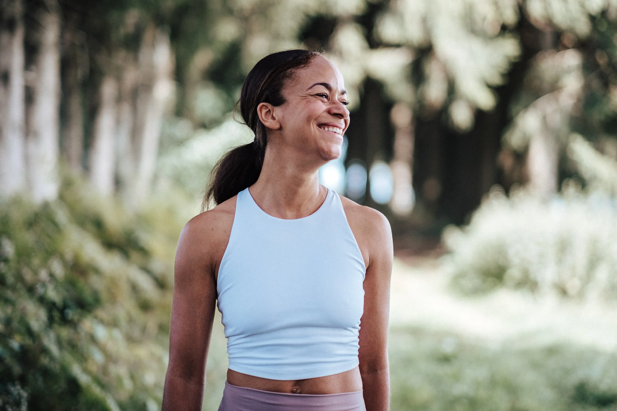 Lächelnde Frau in sportlicher Kleidung im Park