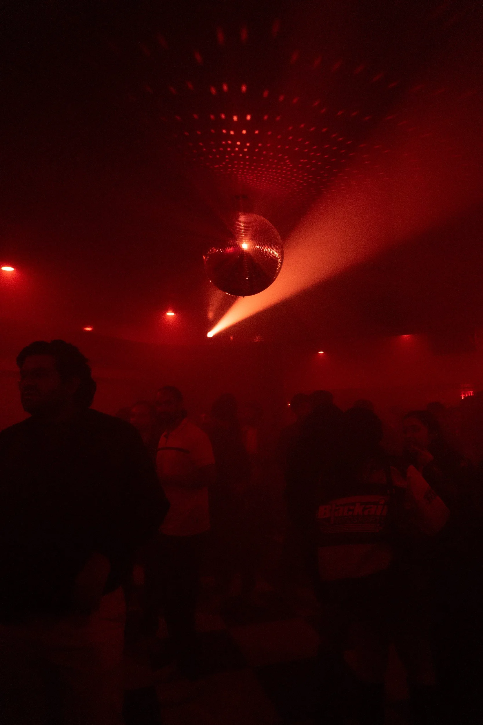 Disco ball and red light above a music event
