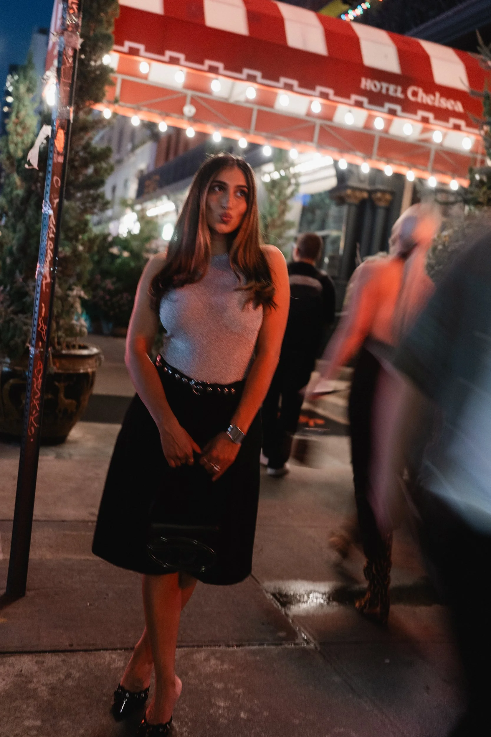Evening fashion portrait beneath illuminated signs