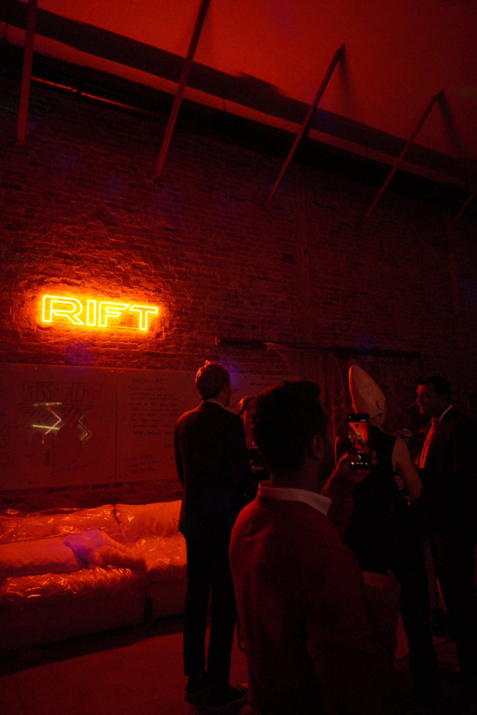 Guests in a red-lit room at a Halloween party