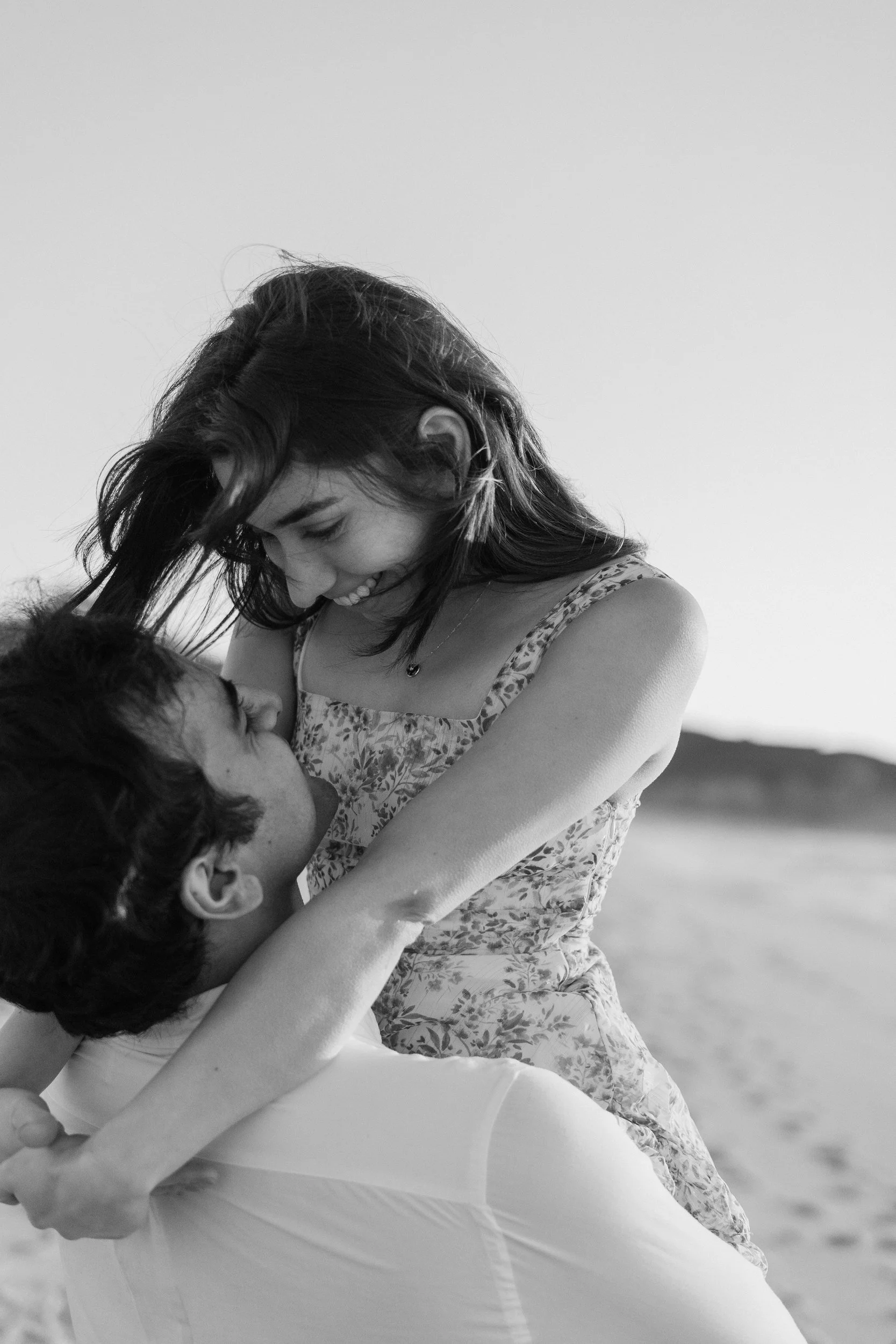 Black and white close-up of a couple embracing on a beach