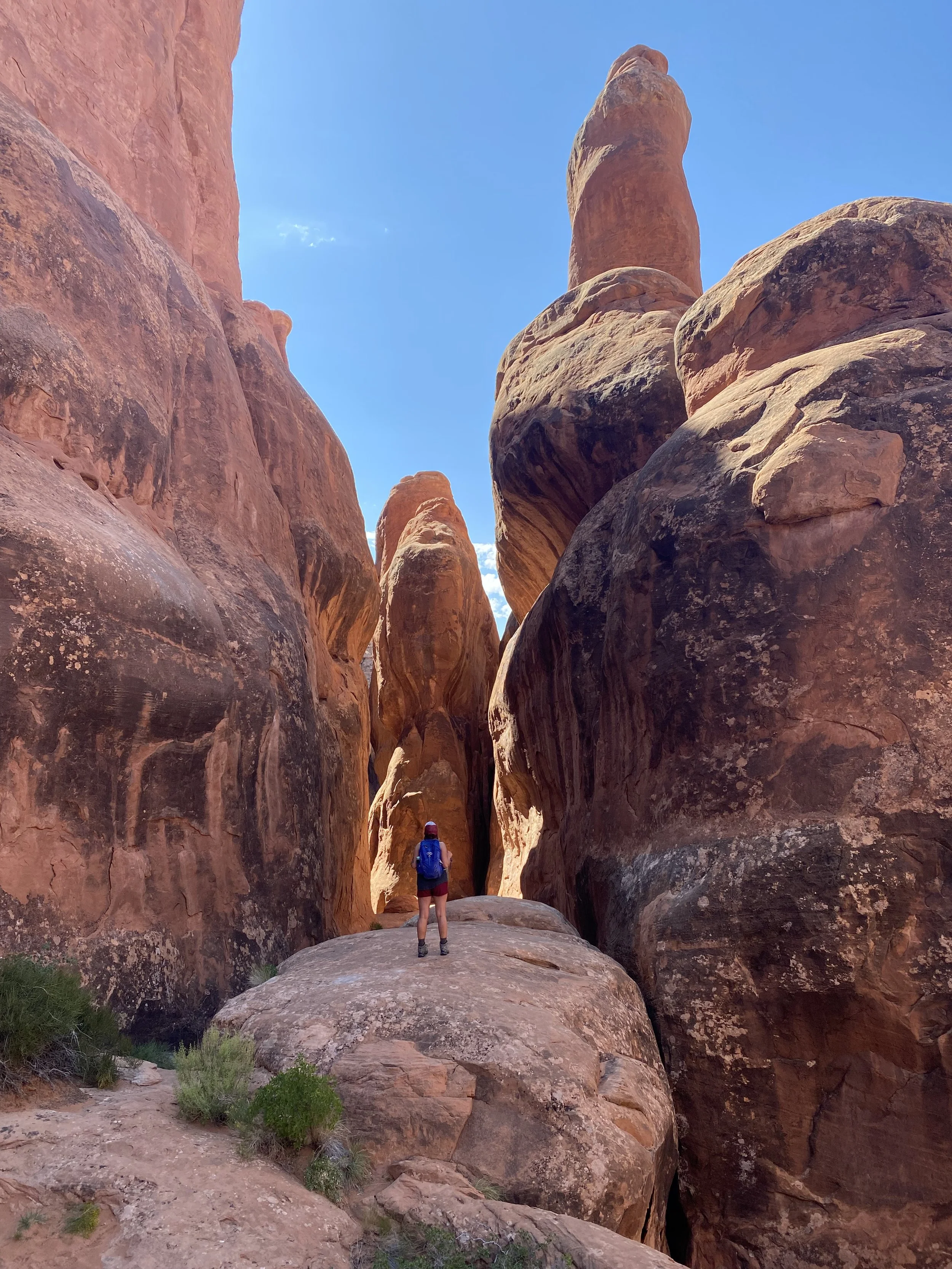 Laura standing beneath red rock Arches in Utah, embodying the spirit of women's adventure retreats in nature