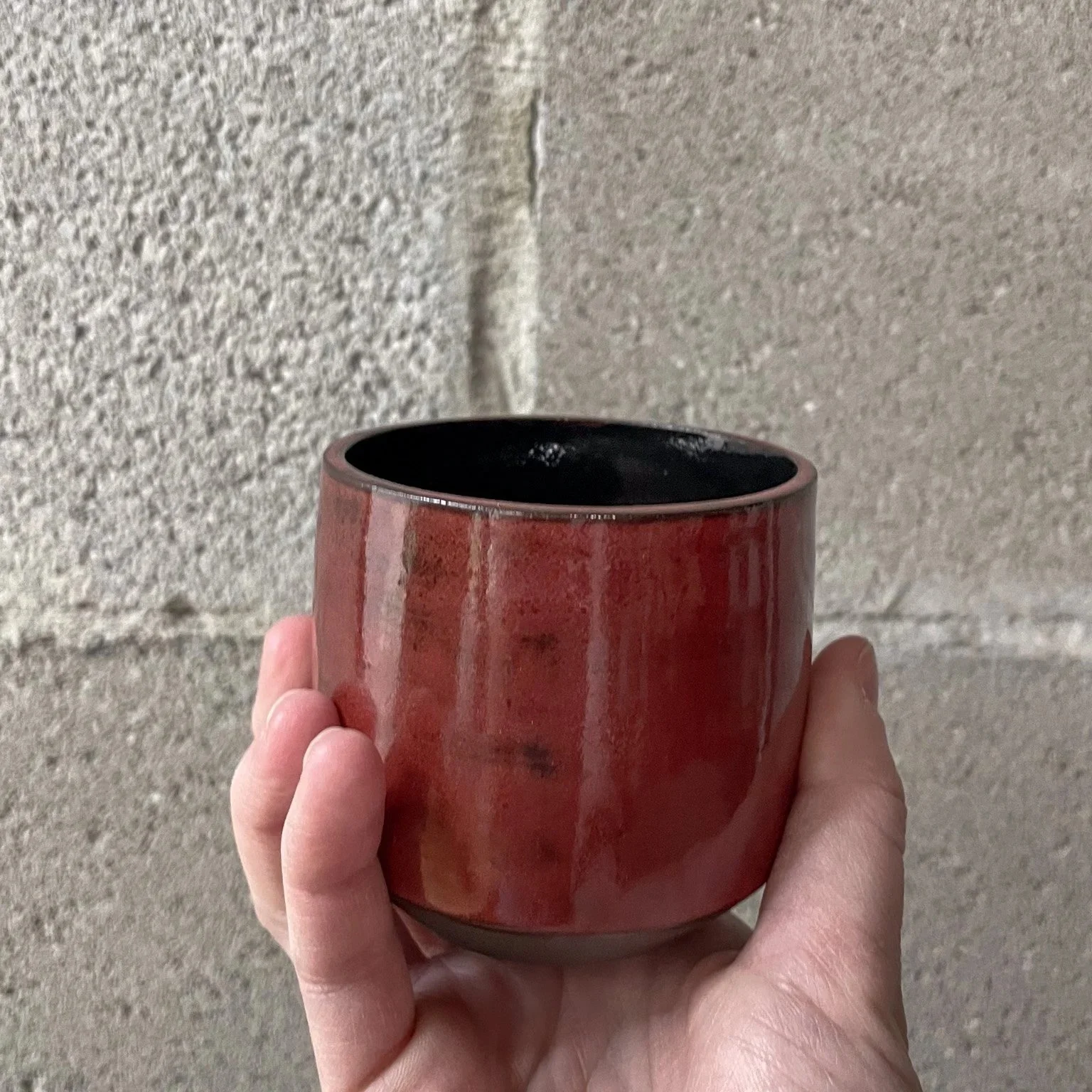 hand-glazed ceramic mug in deep red with gloss black interior, Nordic punk design