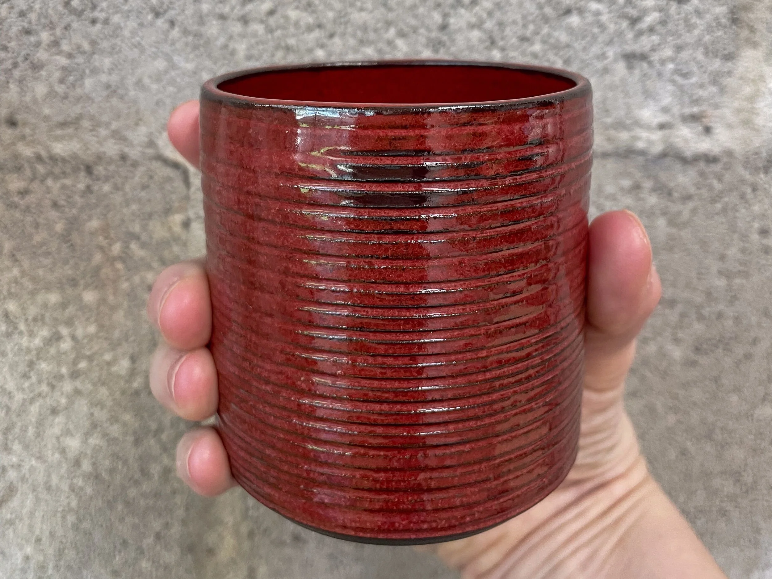 wheel-thrown stoneware mug in deep red glaze, brutalist Nordic form, Wrecked Works