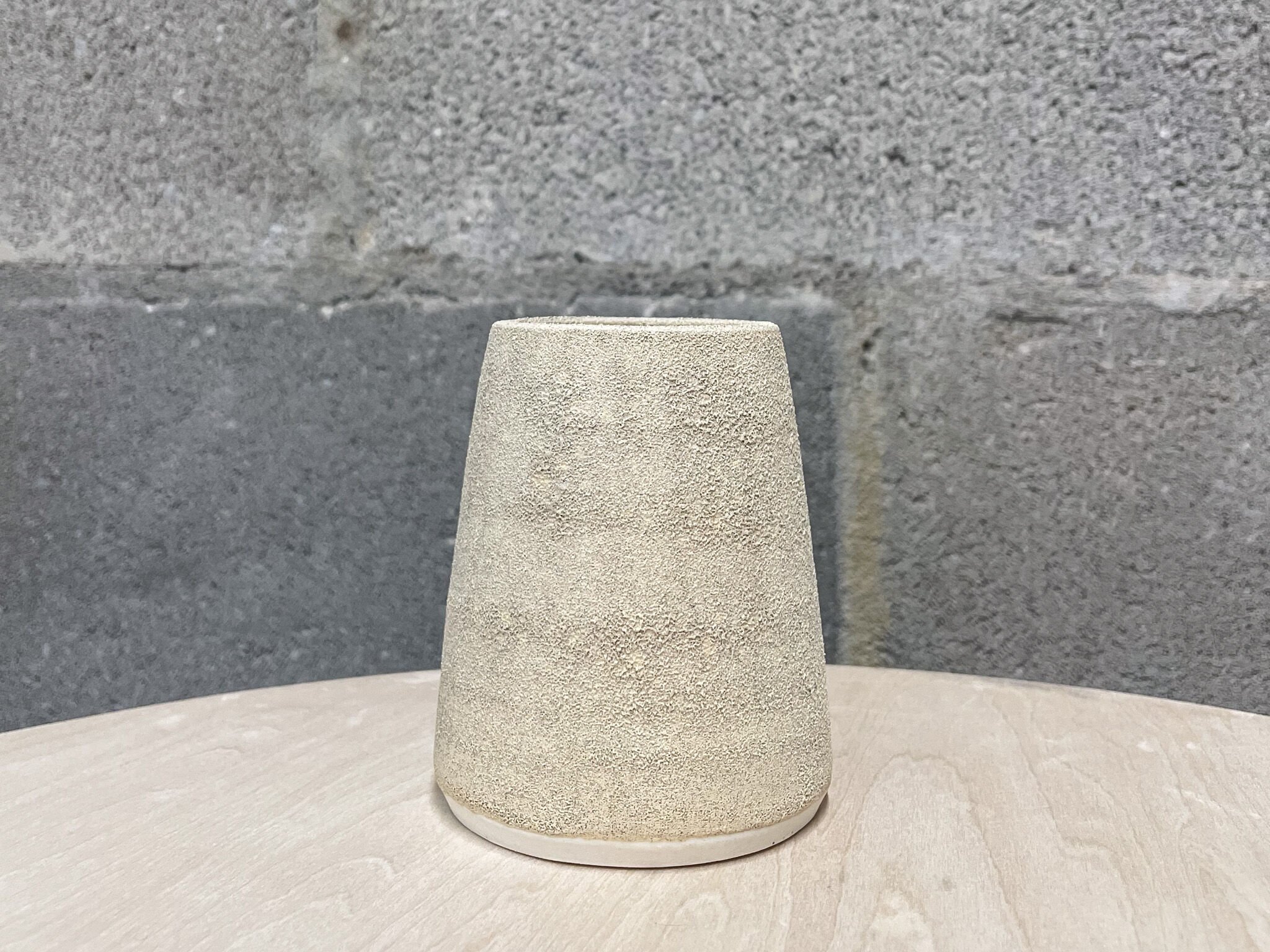 wheel-thrown stoneware flower vase in pale warm glaze, brutalist design, Auburn Alabama