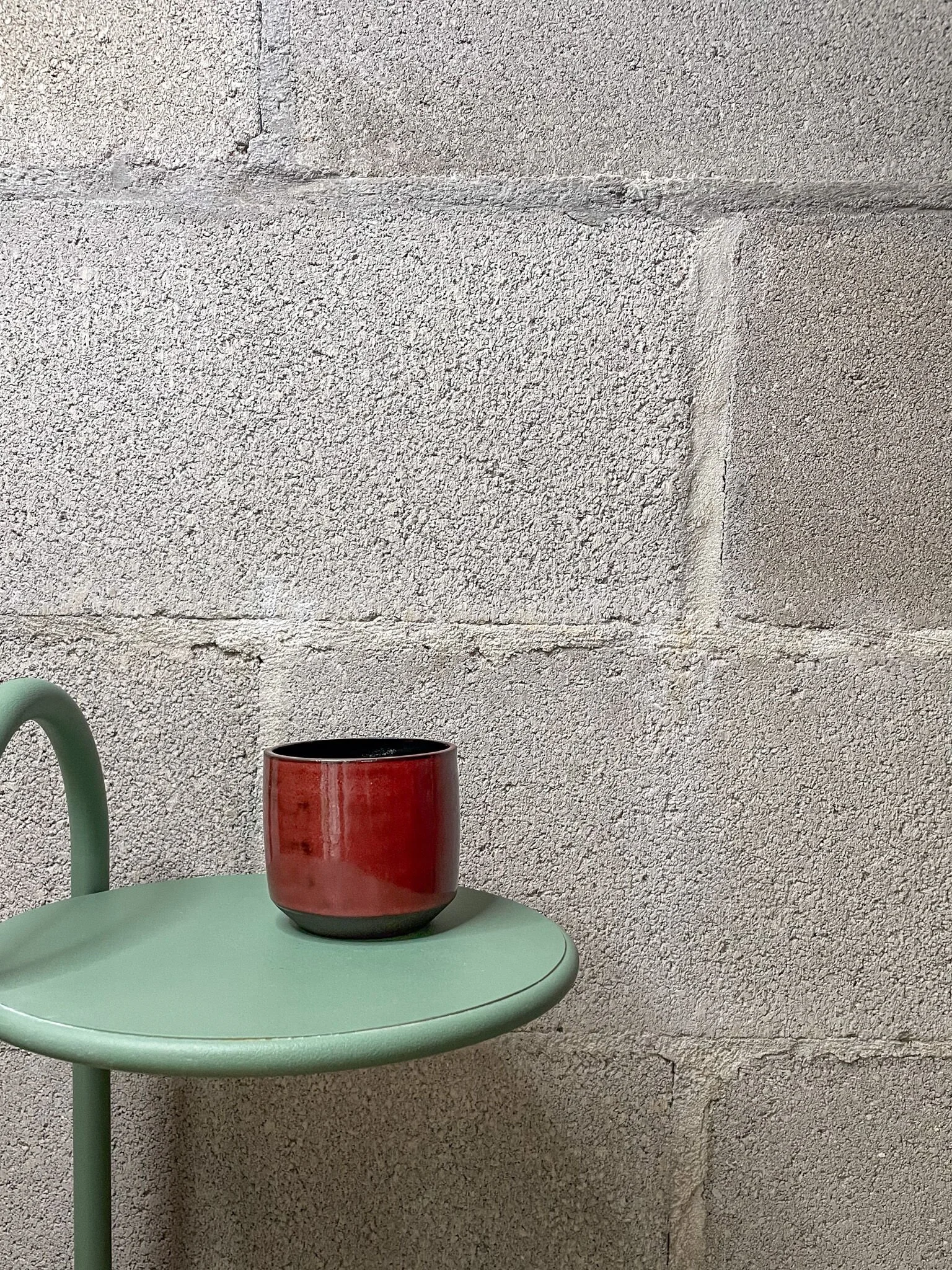 wheel-thrown stoneware cup in glossy red with black interior, brutalist angular form
