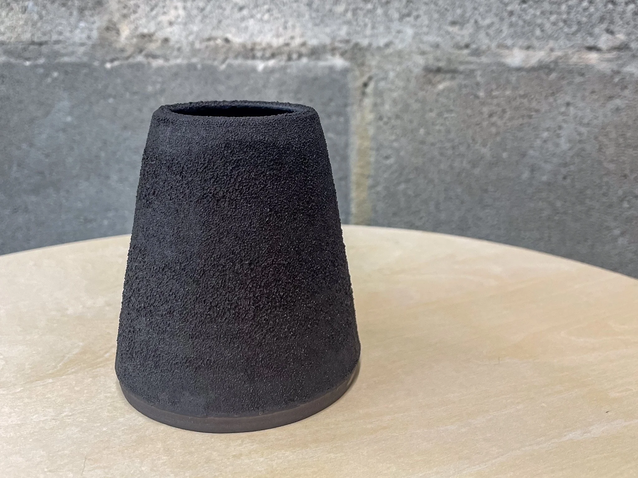 wheel-thrown stoneware vase in dark textured glaze, brutalist tapered form