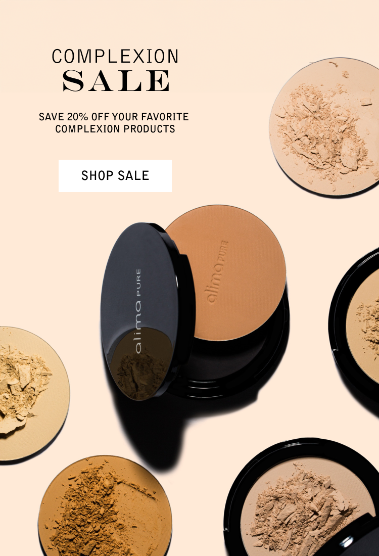 Advertisement for a sale on complexion products with a beige background, featuring several loose powder makeup products with their lids off, showing the pressed powders inside, and a central compact with a reflective lid.