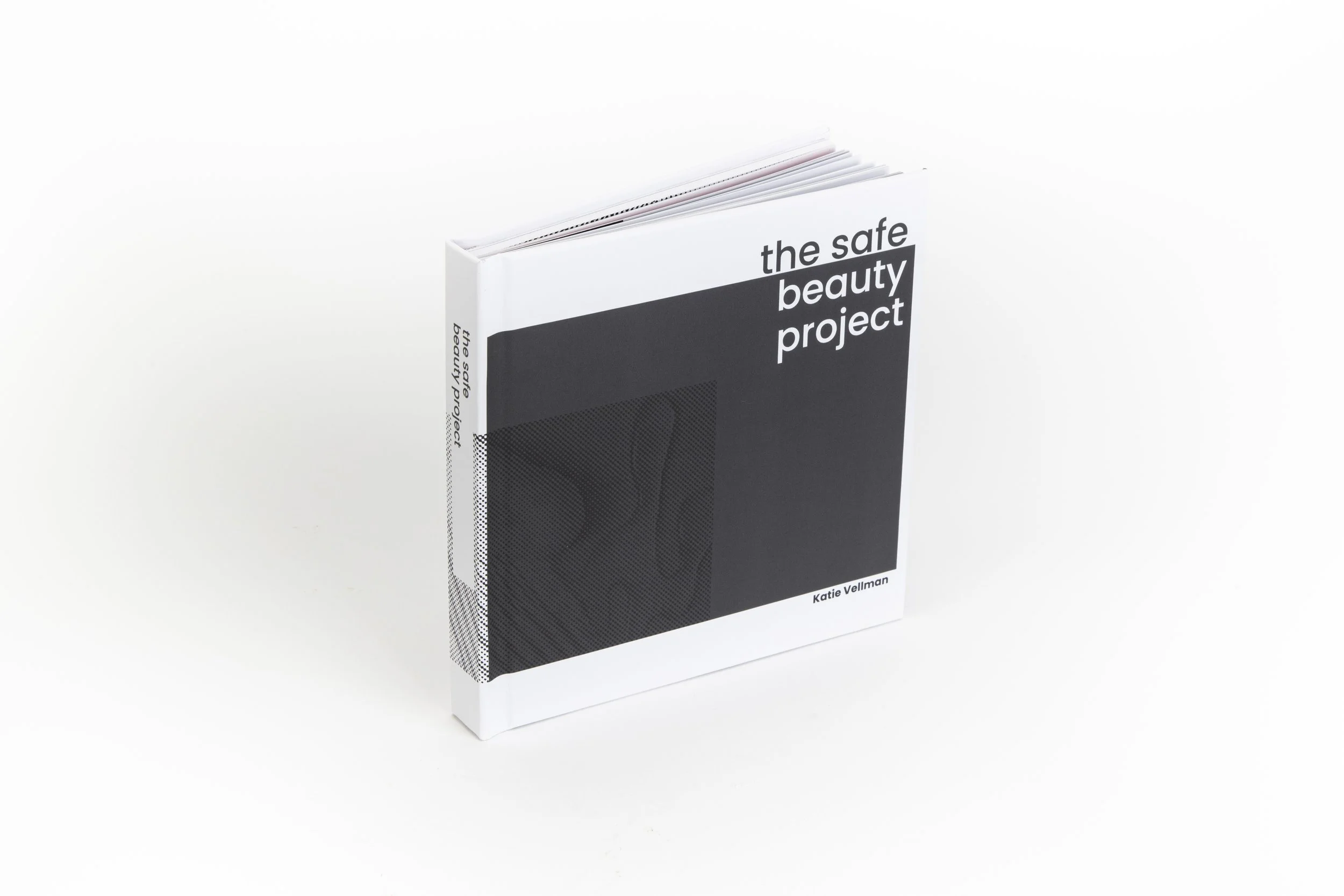 A booklet titled 'the safe beauty project' by Katie Vellman, with a minimalist black and white cover design, standing upright on a white background.