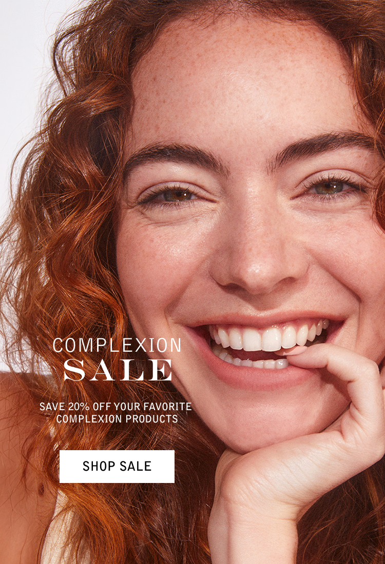 Close-up of a smiling woman with curly red hair promoting a sale on skincare products.