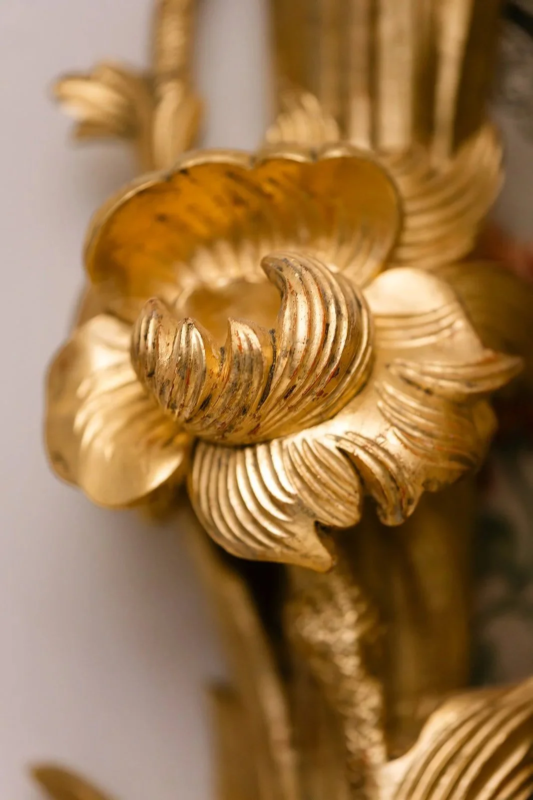Close-up of a decorative gold floral or leaf-shaped ornamental piece with detailed ridges and shiny finish.wedding location