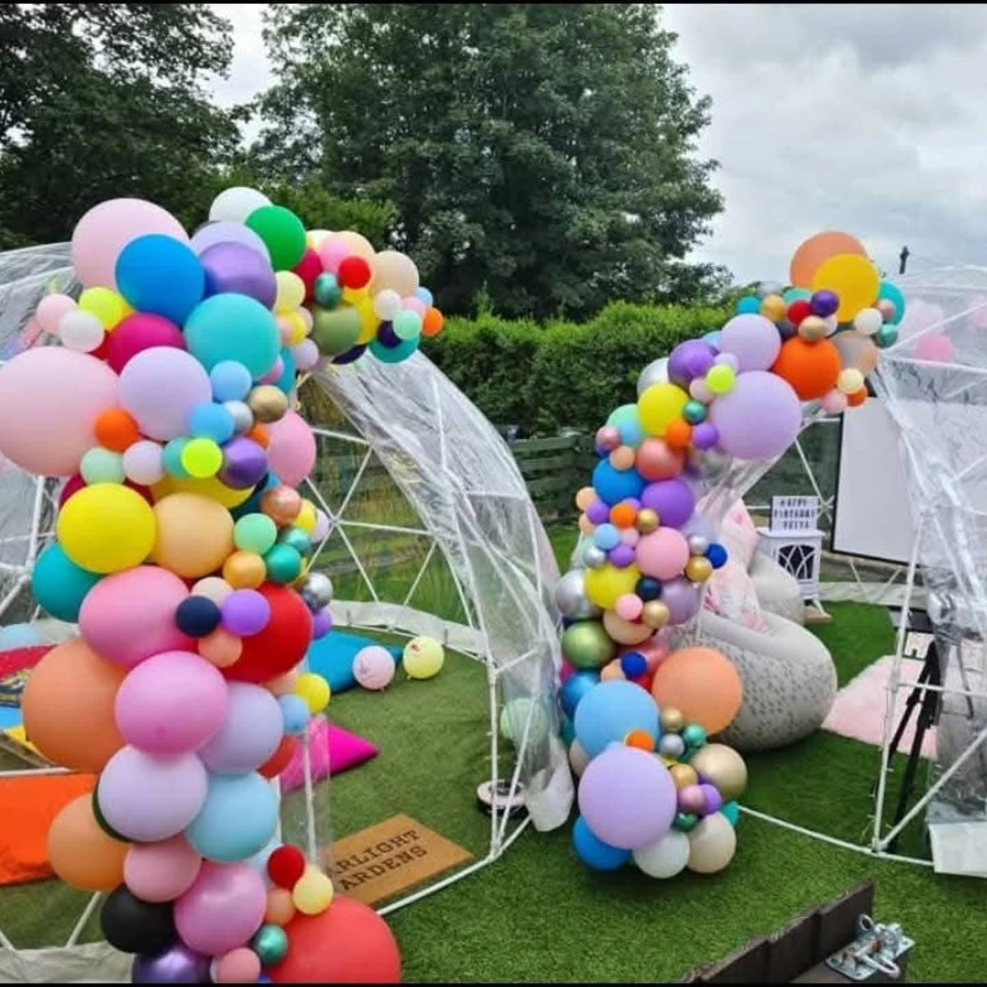 Colorful balloon decorations forming an arch at an outdoor event.