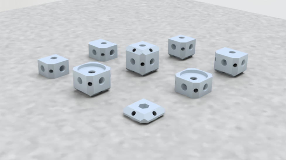 Collection of various small, light-grey plastic or ceramic dice with different arrangements of holes on their surfaces, placed on a light-colored surface.
