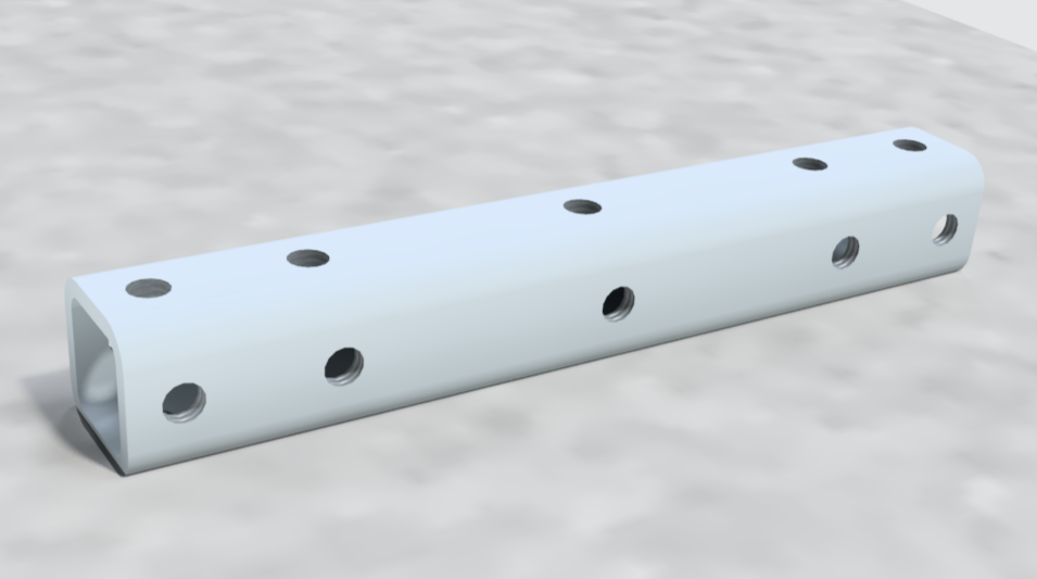 A white cylindrical metal tube with multiple evenly spaced holes along its length, lying on a gray surface.