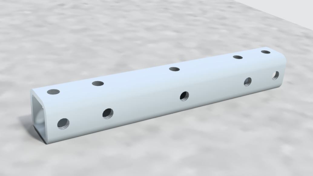 A white metal rectangular tube with multiple evenly spaced holes along its length, lying on a textured gray surface.