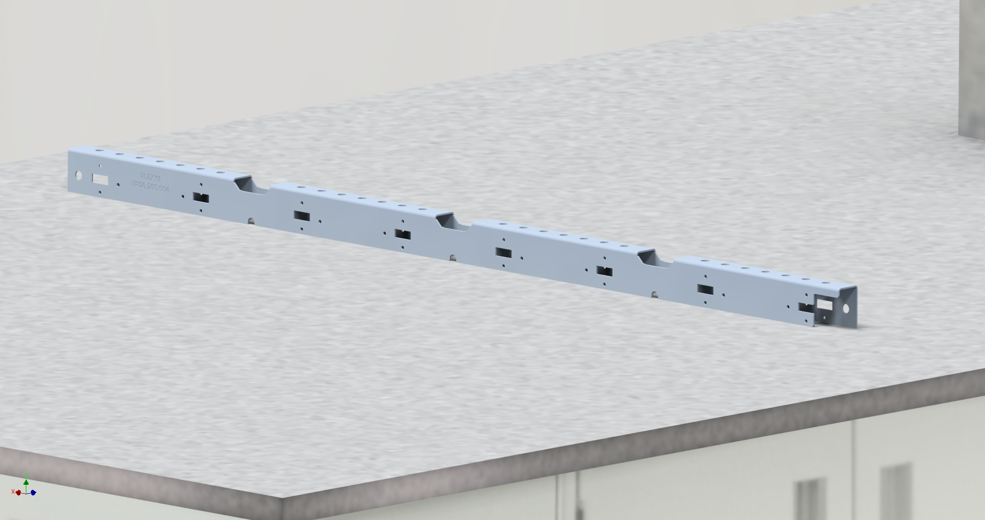A U-profile with multiple cutouts, placed on a grey speckled surface in an indoor setting.