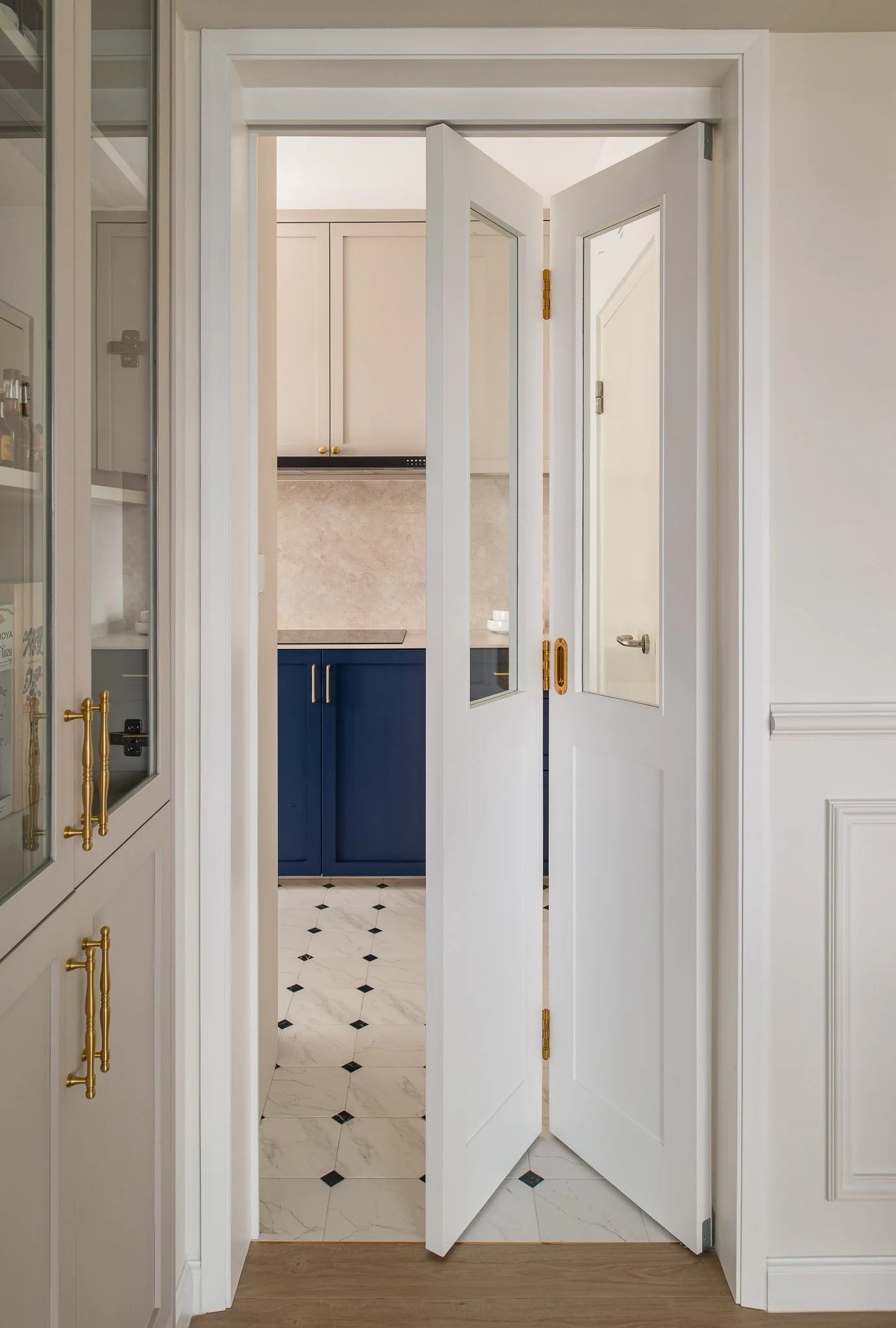 cream and navy shaker kitchen with brass fixtures and patterned floor tiles
