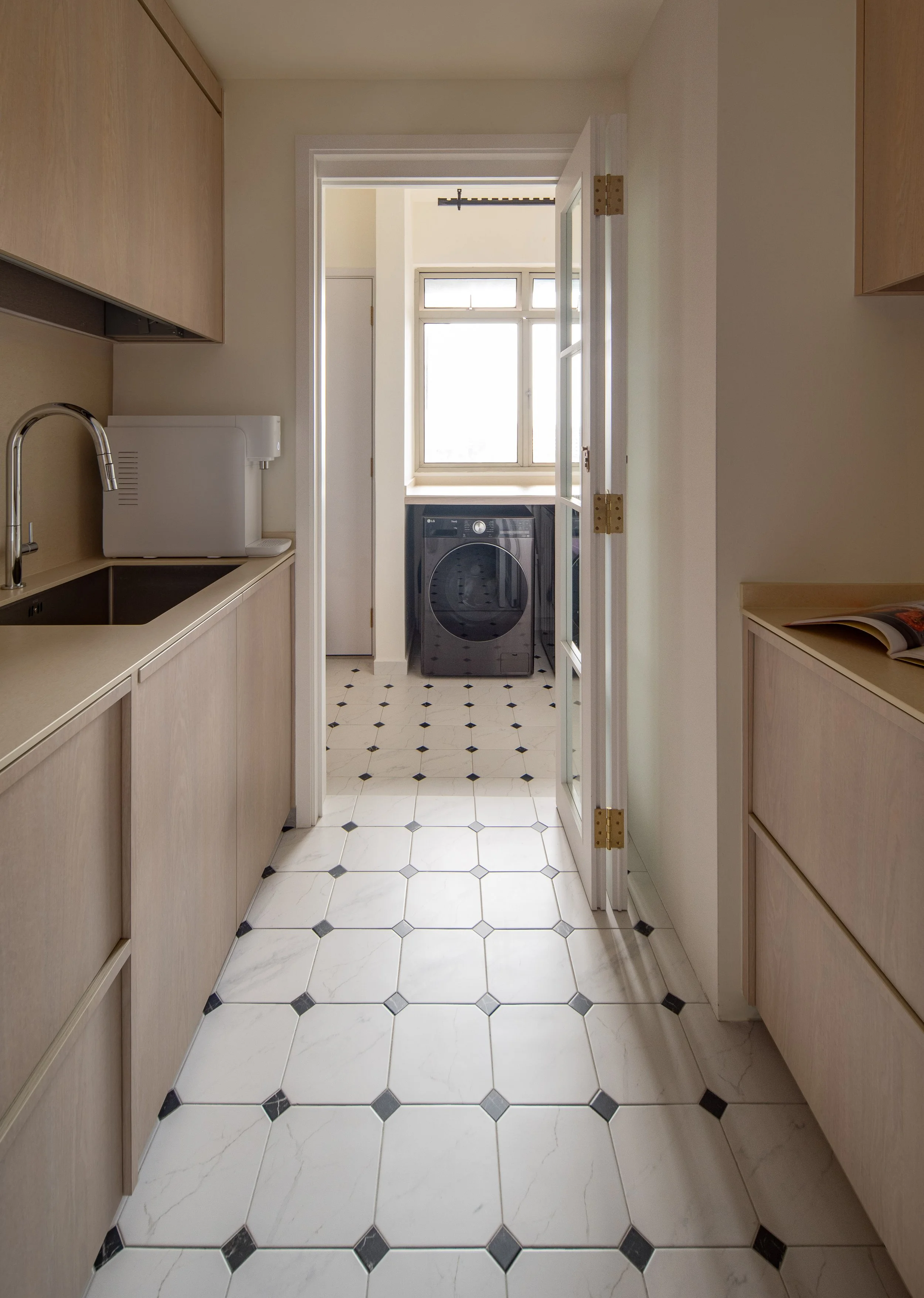 Wood-tone kitchen with glass French door to laundry and patterned tile floor