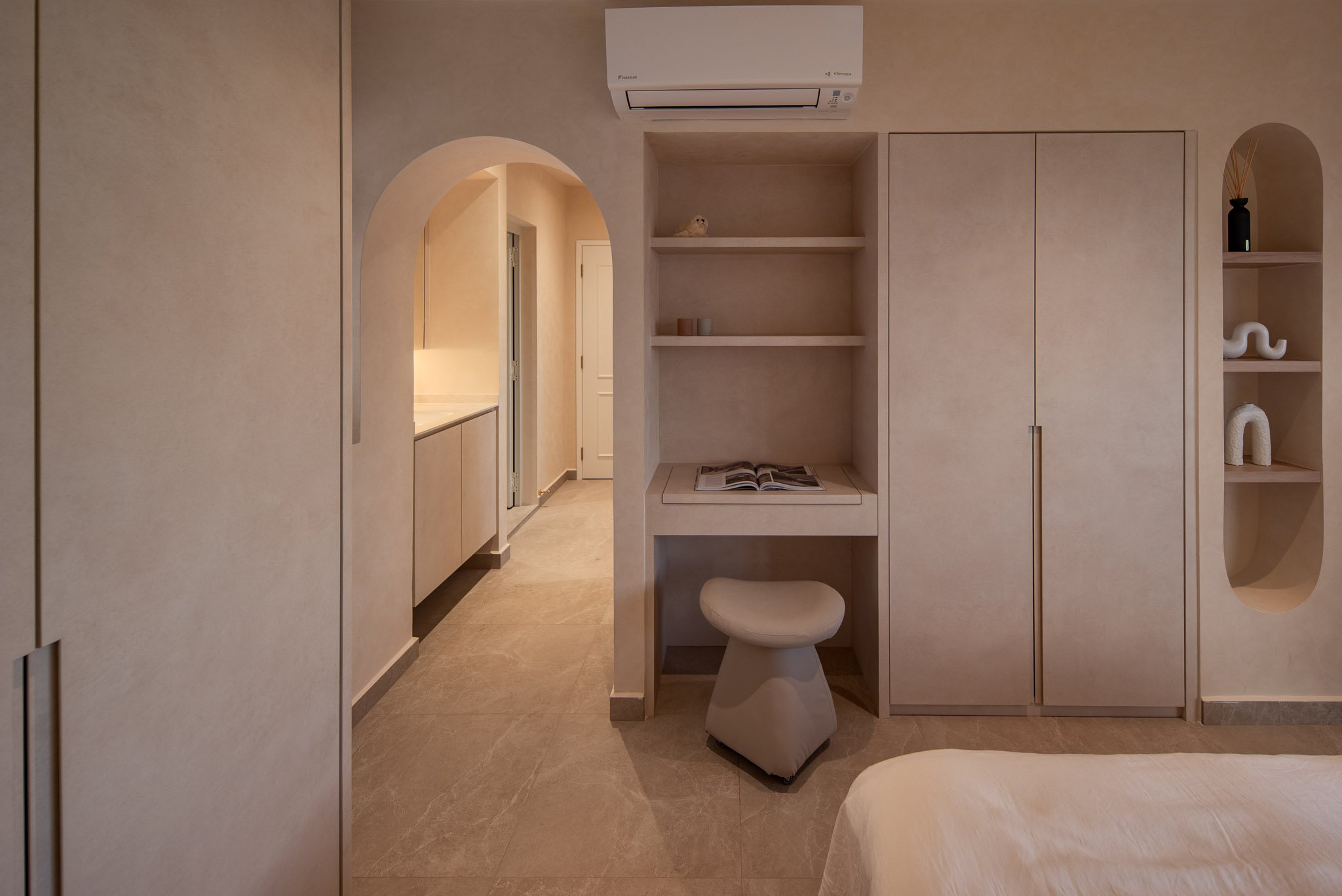 Wabi-sabi bedroom with arched doorway, built-in desk and wardrobe