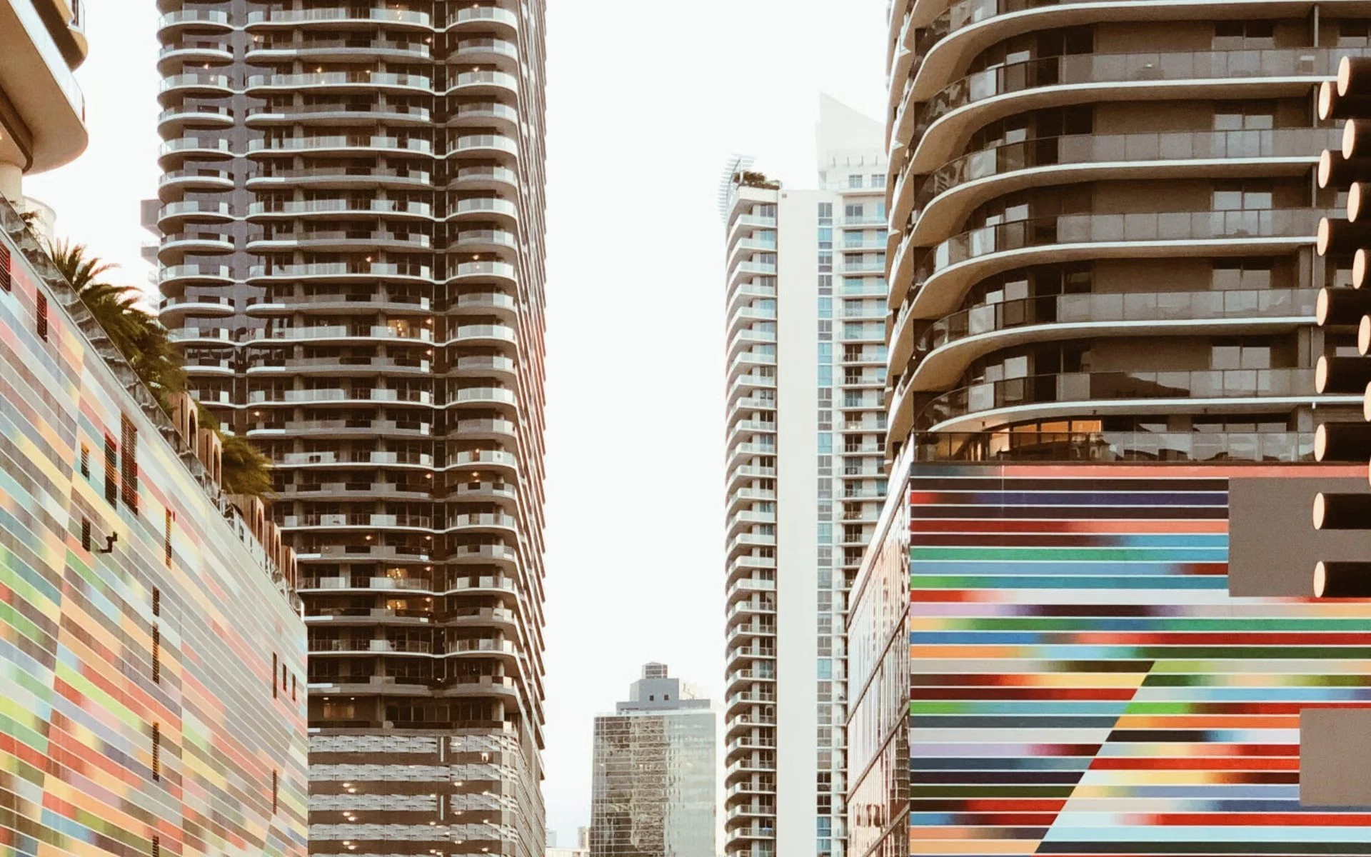 Cityscape with tall modern buildings and colorful murals on walls