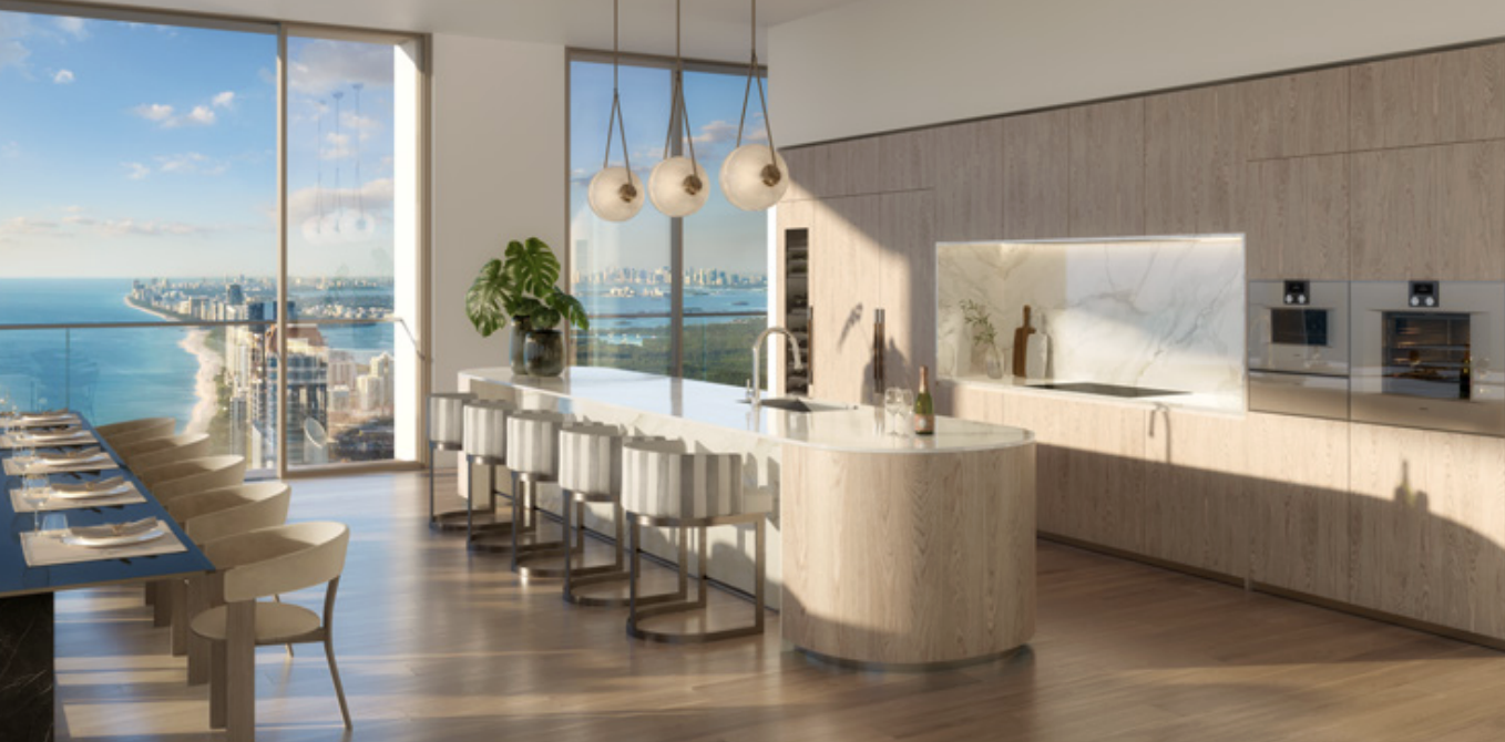 Modern kitchen with a large ocean view, featuring a white marble island, beige bar stools, pendant lighting, and built-in oven and microwave, with wooden floor and paneling.