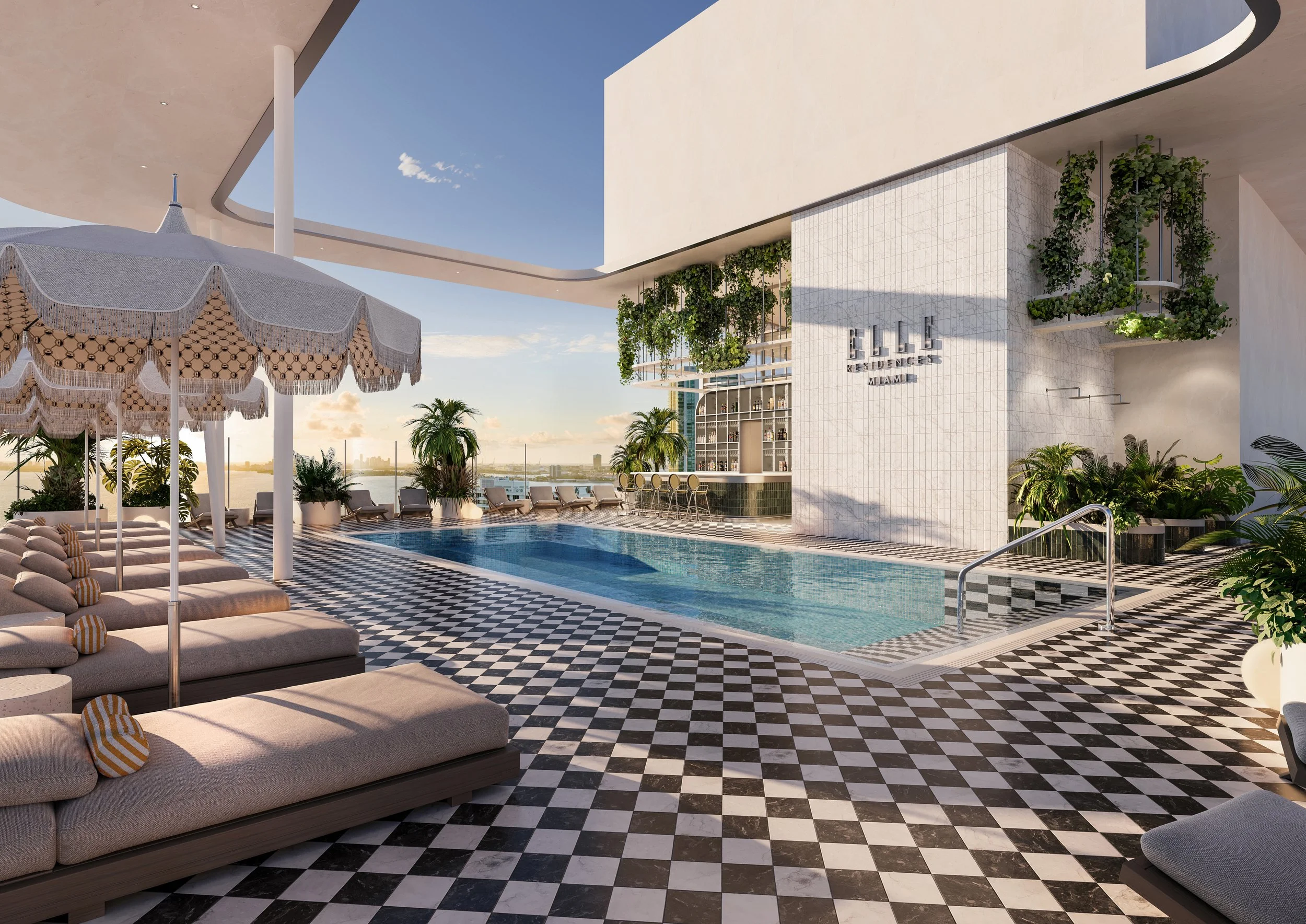 Luxury rooftop pool area with sun loungers, umbrellas, palm trees, and modern architecture, overlooking a city skyline.