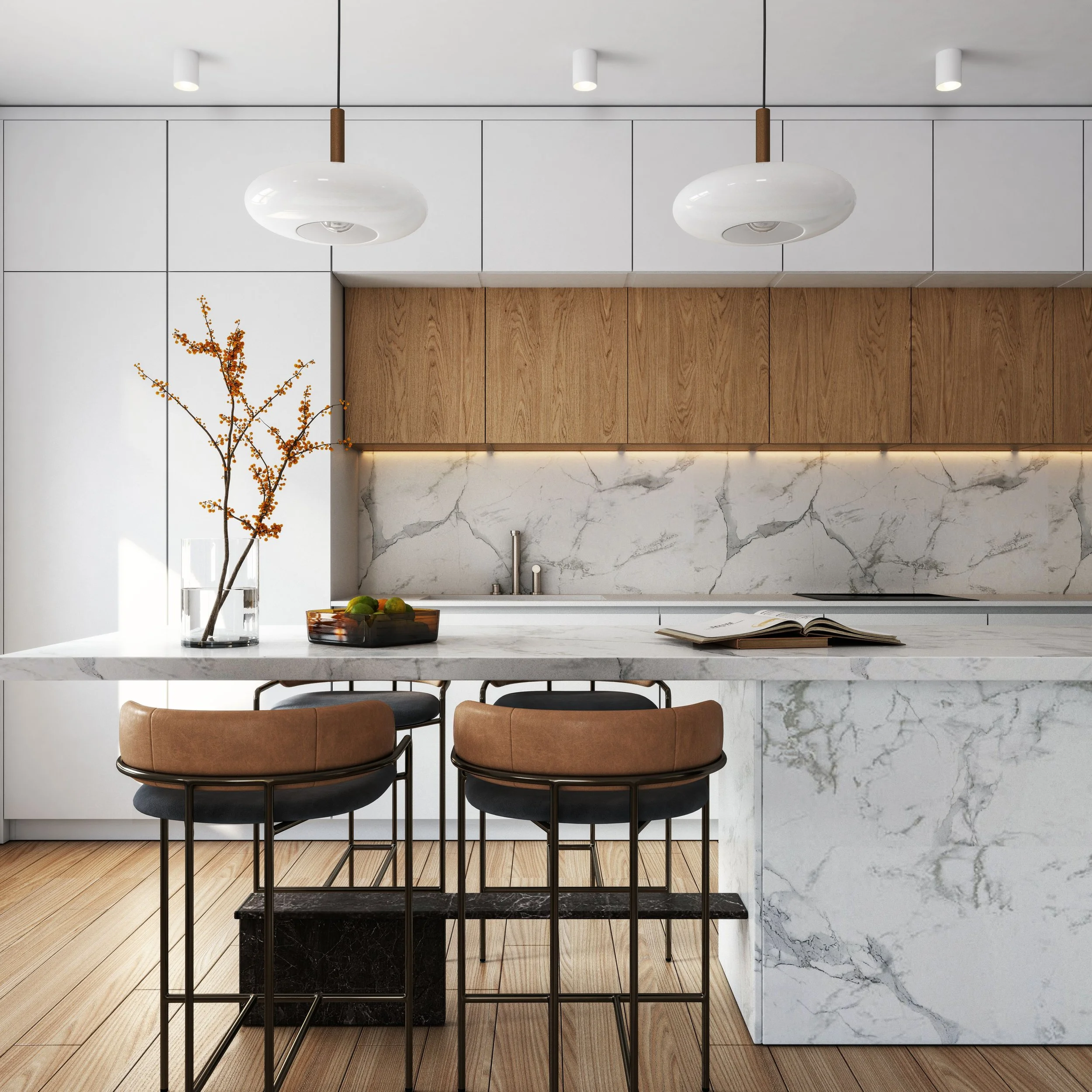 Modern kitchen with white marble island, wooden cabinets, and minimalist decor, including a glass vase with branches and a bowl of fruit.