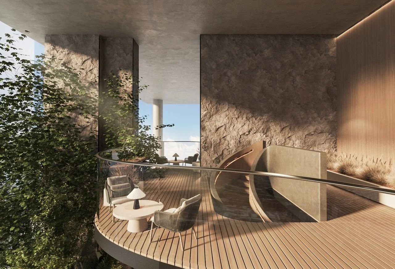 Modern outdoor balcony with wooden flooring, glass railing, and seating area with a small round table, chairs, and a lamp. Surrounded by greenery and view of the sky and clouds in the background.