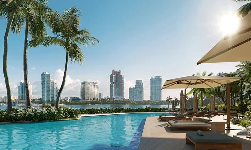 A luxurious poolside scene with palm trees, sun loungers, and umbrellas beside a city skyline with high-rise buildings under a clear blue sky.