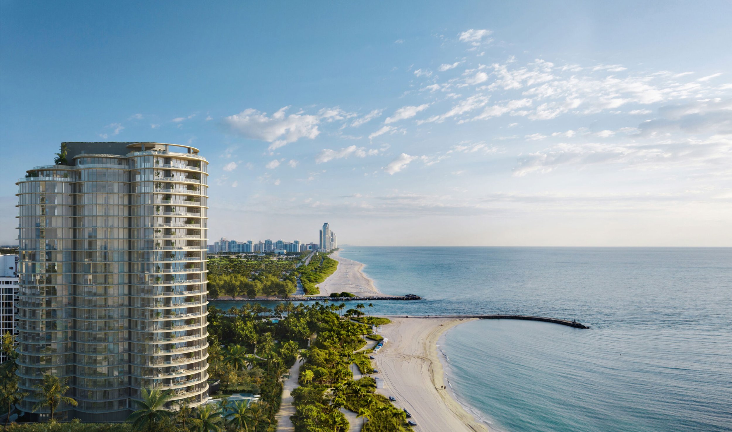 Aerial view of high-rise beachfront condominiums overlooking the ocean with a sandy beach, green trees, and a clear blue sky.