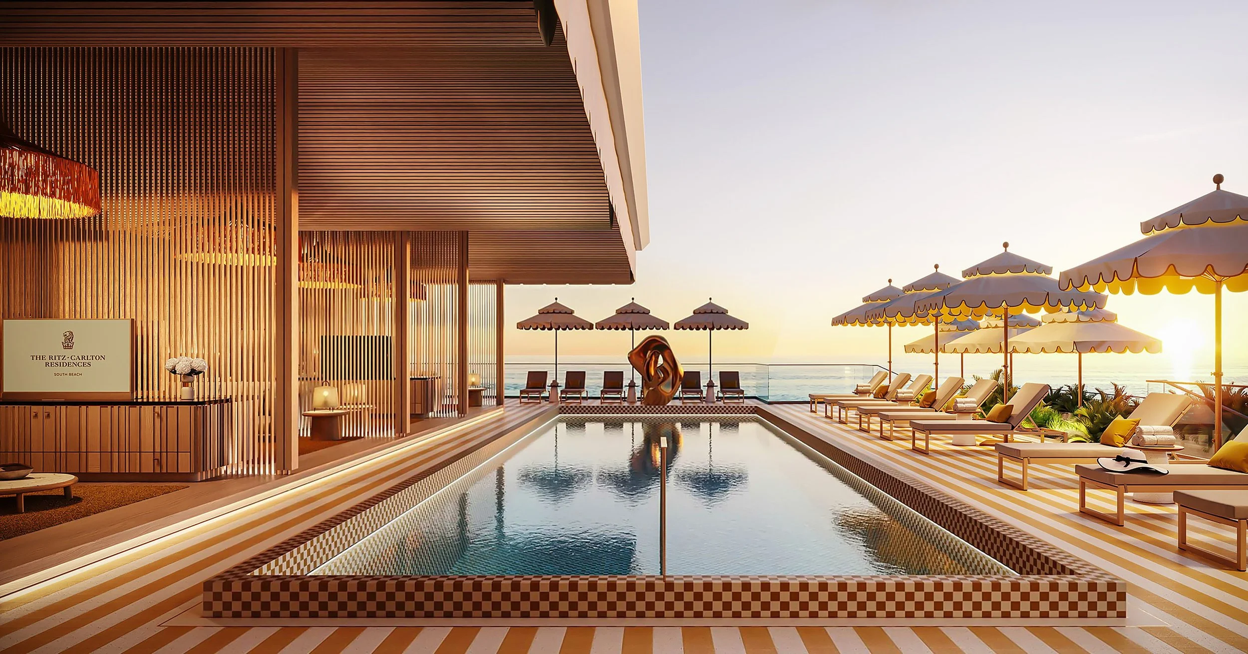 Luxury hotel rooftop pool area with sun loungers, umbrellas, and ocean view at sunset.