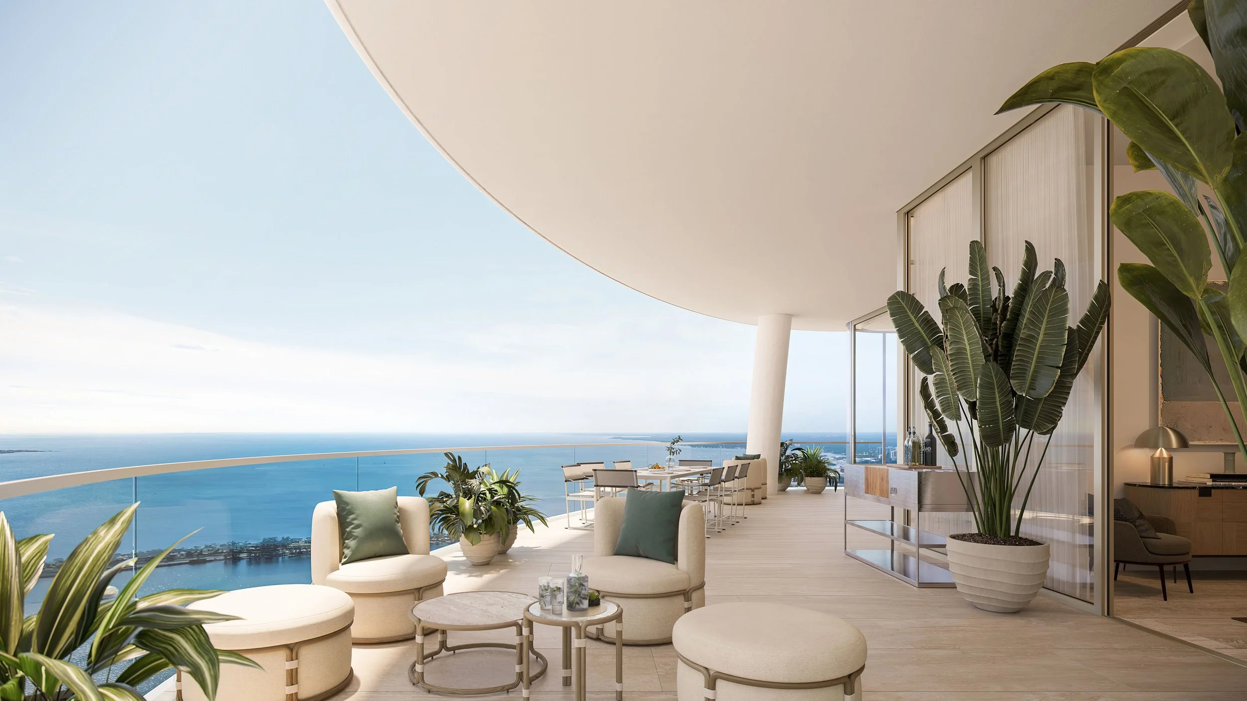 Modern outdoor balcony with white furniture, potted plants, and ocean view under clear sky.