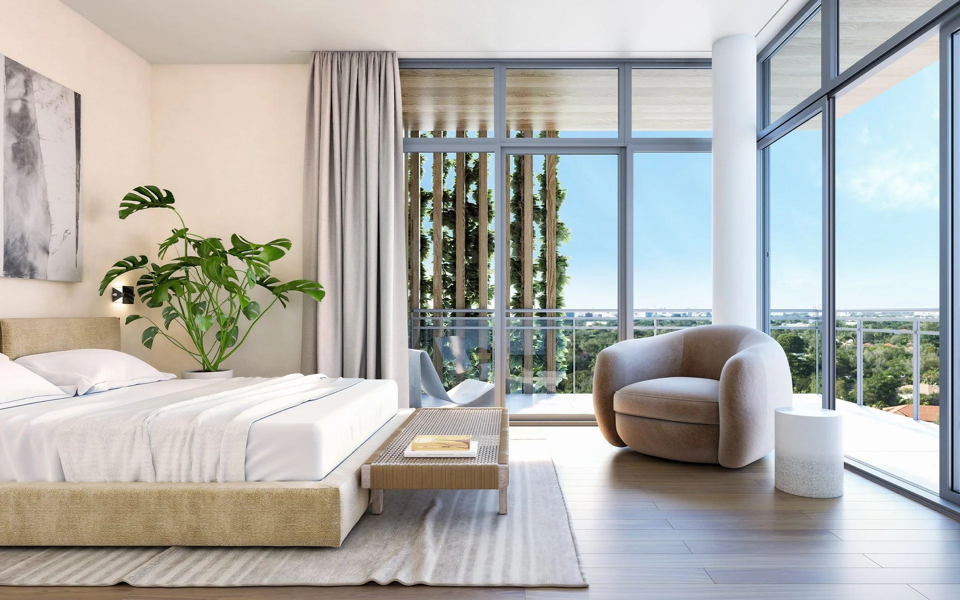 Modern bedroom with large glass windows, a white bed with a beige upholstered frame, a potted plant, a plush beige armchair, and a small round side table, overlooking a city view with trees.