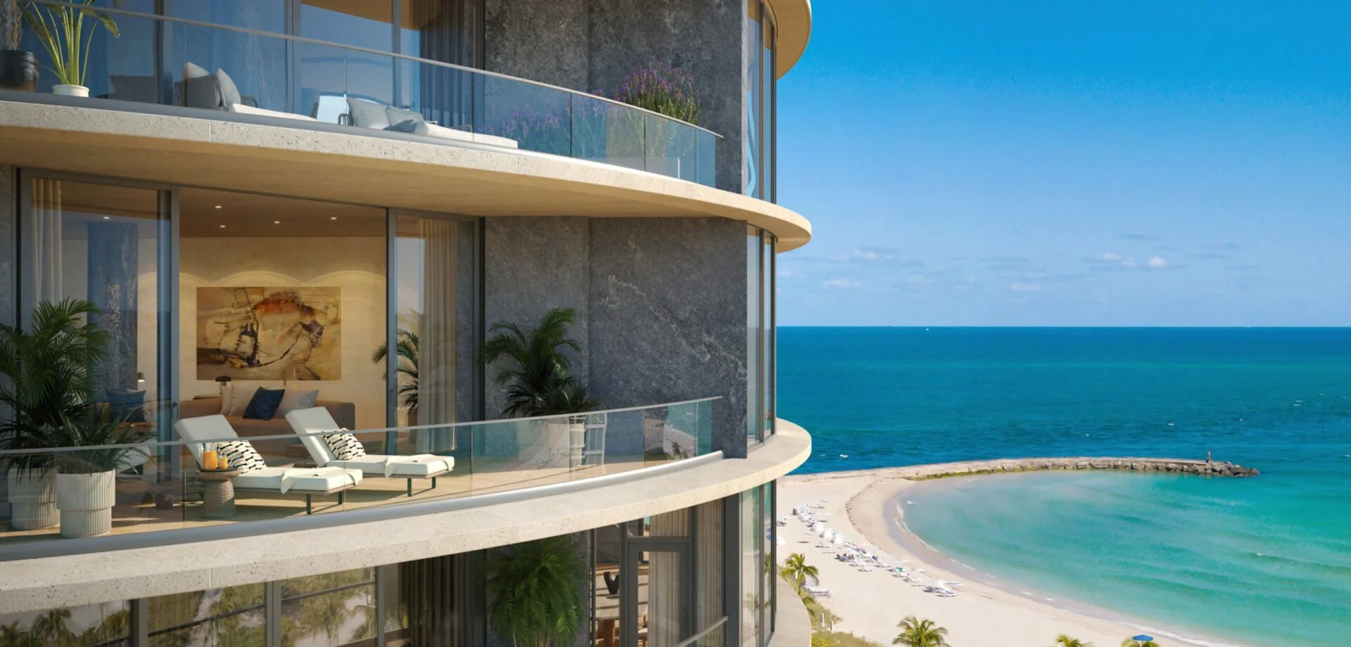 View of a modern beachfront apartment building with balconies overlooking a sandy beach and the ocean under a clear blue sky.