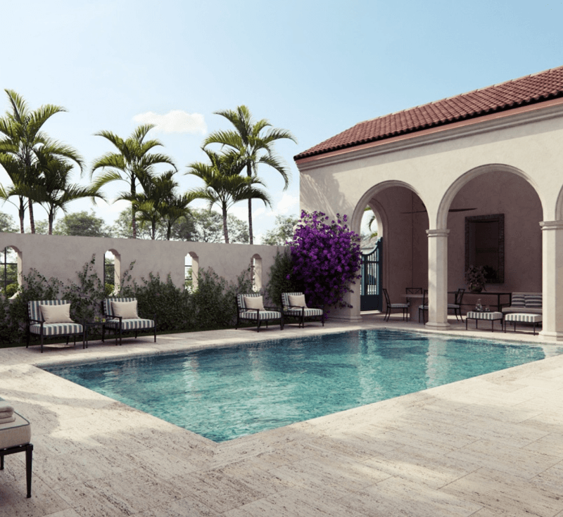 A luxurious outdoor swimming pool area with lounge chairs, surrounded by a white wall, palm trees, and a Mediterranean-style building with arches and red-tiled roof.