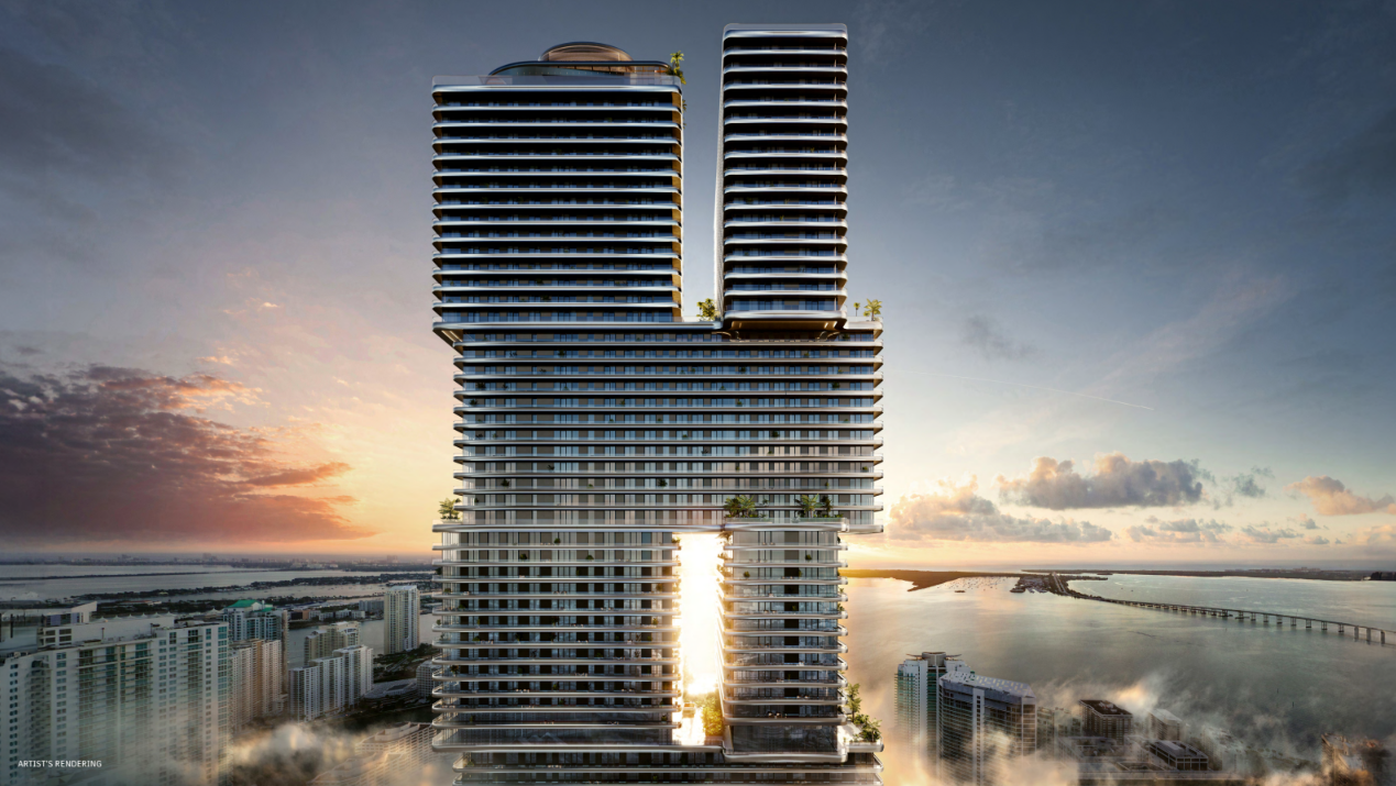 A modern high-rise building with two vertical towers connected by platforms, set against a sunset sky with water and cityscape below.