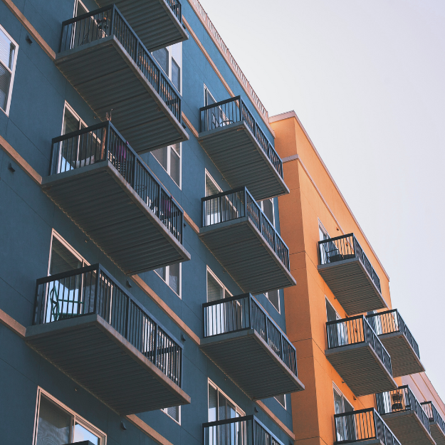 Multiple balconies on a blue and orange apartment building