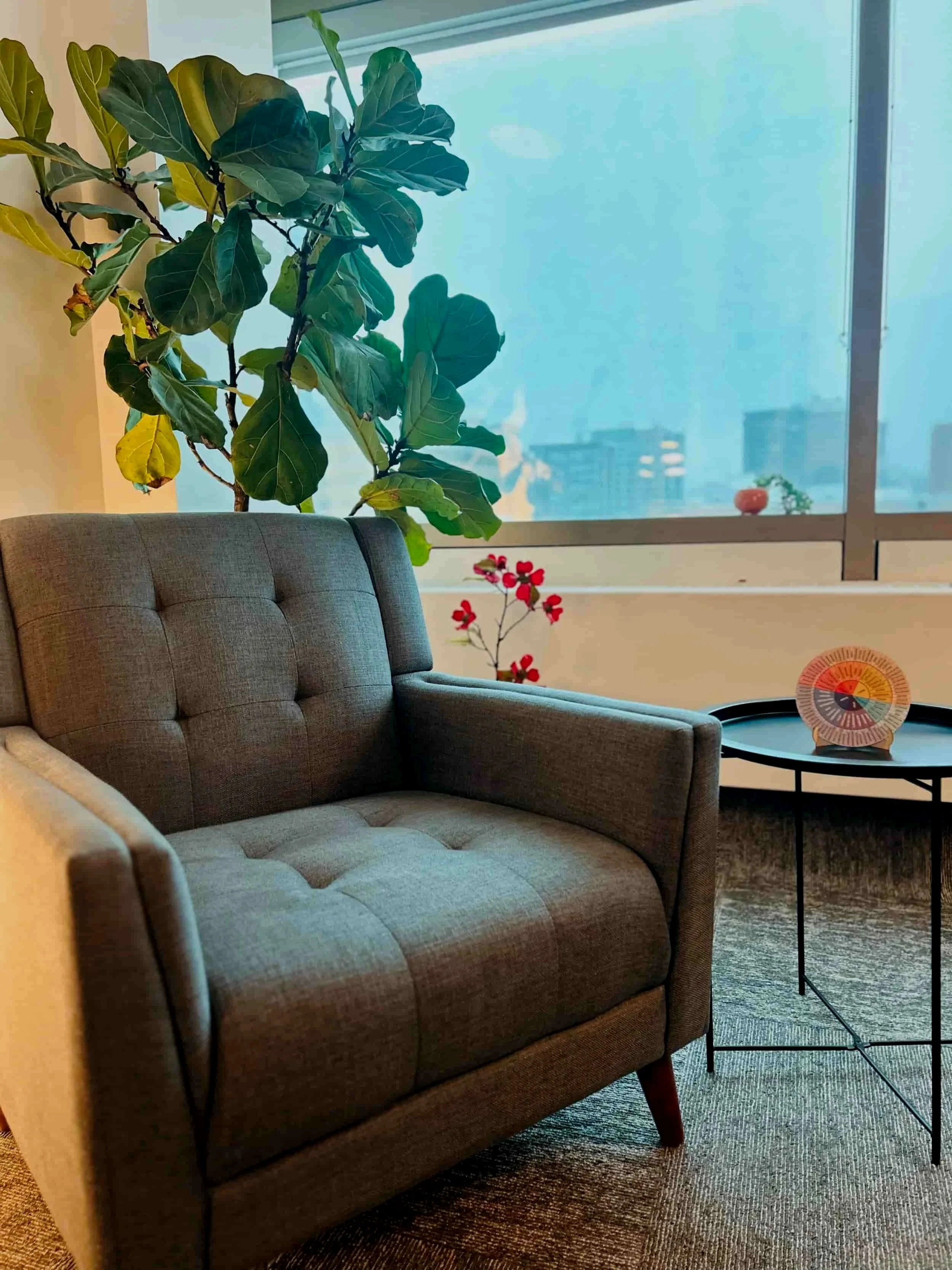 An image of a couch on the the backdrop of the Edmonton skyline inside Psychologist Samantha Greenwood clinic. - psychologist-for-healthcare-workers-edmonton therapy-for-high-achieving-professionals-edmonton