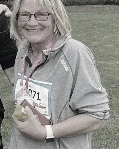 A smiling woman who has completed a race following injury rehab supported by weight management advice from a registered dietitian and sports nutritionist. The race was held in Middlesbrough, Cleveland.
