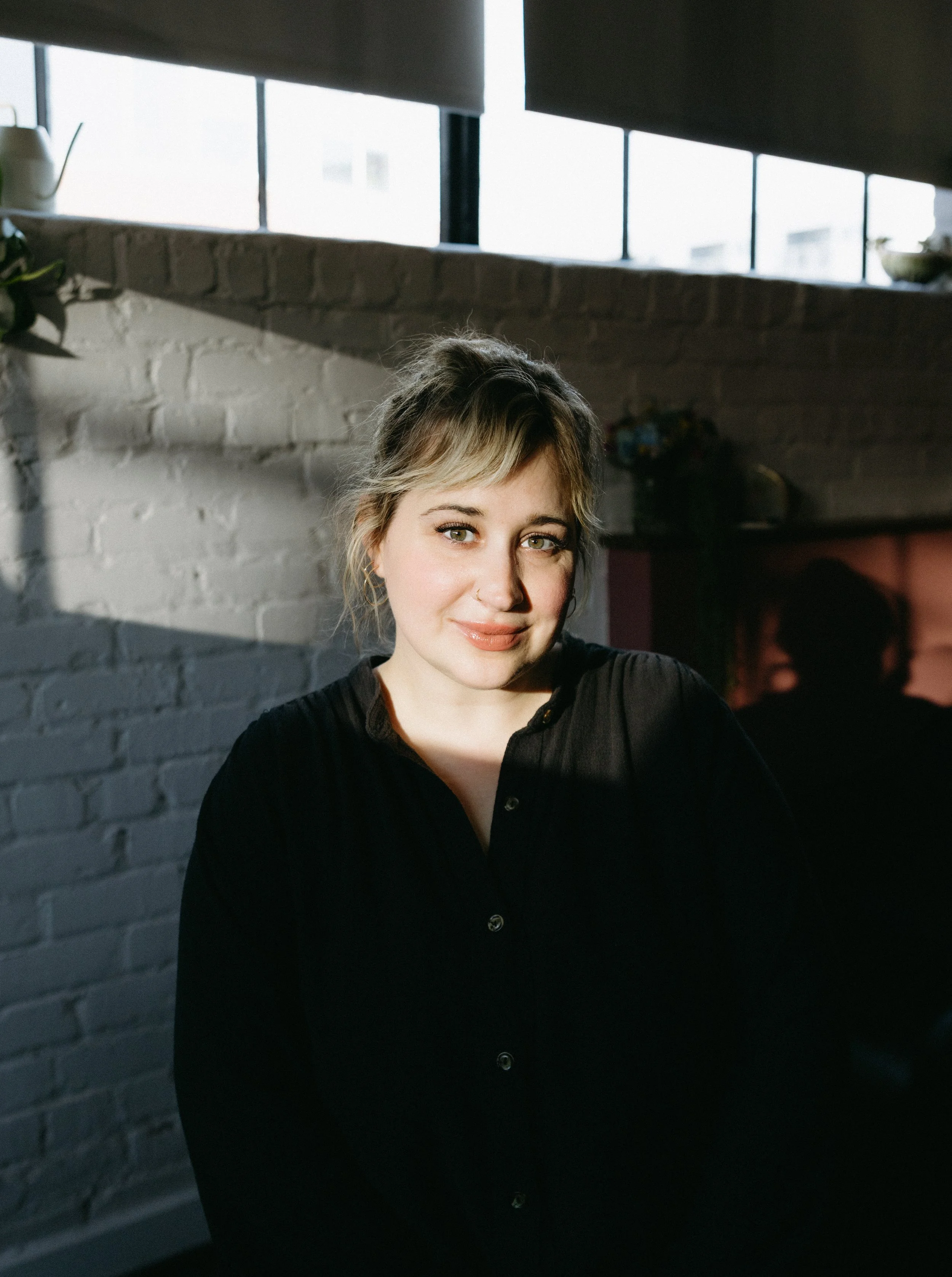 Portrait of JoAnn, a blonding and razor-cut specialist in Richmond VA, standing in natural light inside the salon.