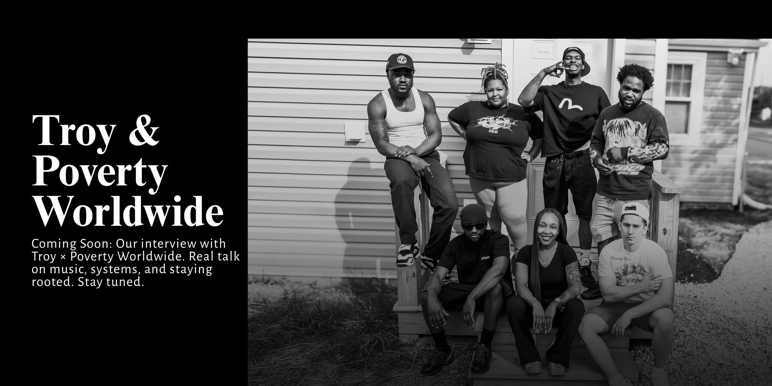 Black and white photo of eight members of Poverty Worldwide posing outdoors in front of a house.
