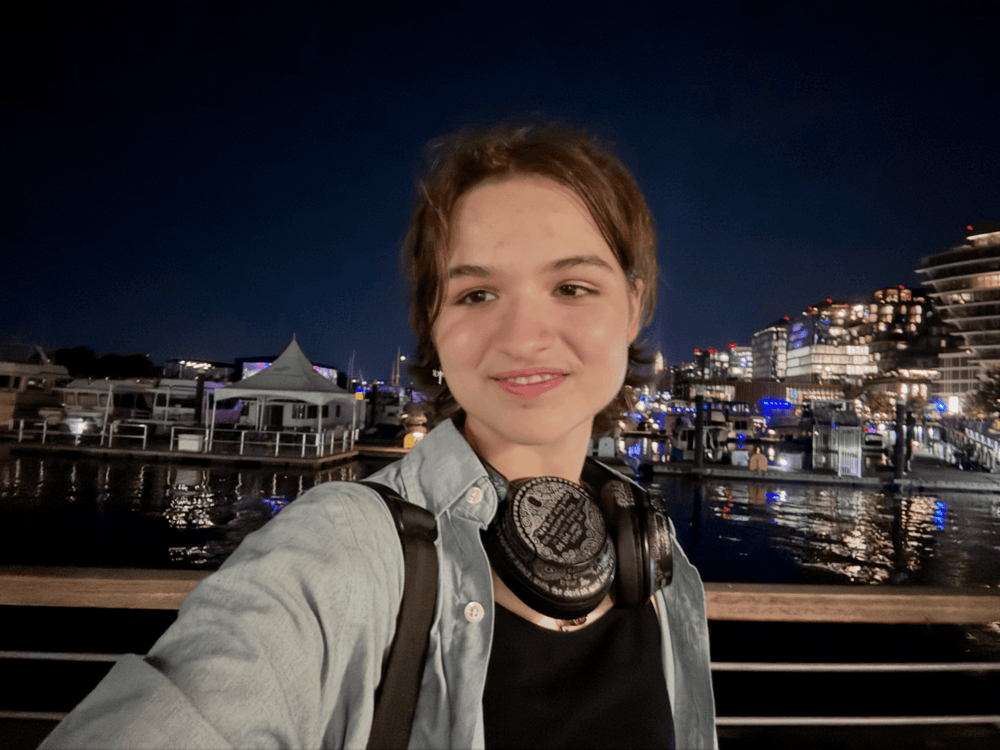 Evyia stands in front of a harbor.