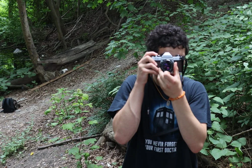 Photographer Yaakov Ellis holds his camera up.