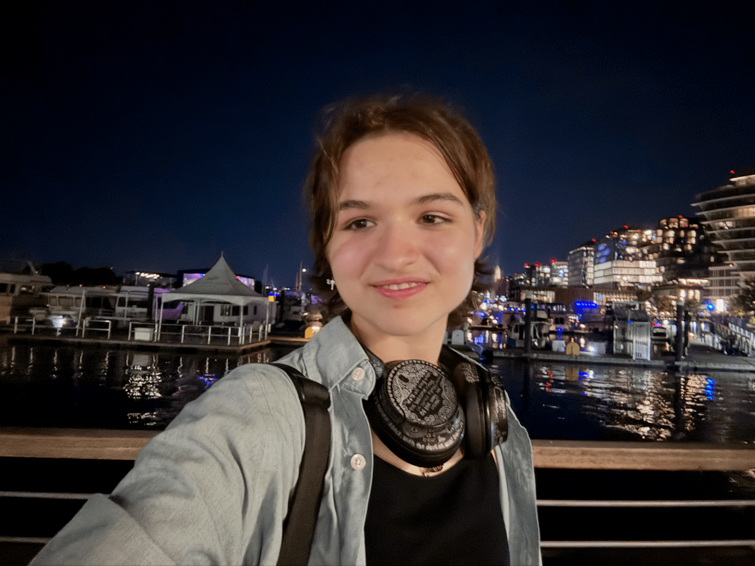 Evyia stands in front of a harbor.