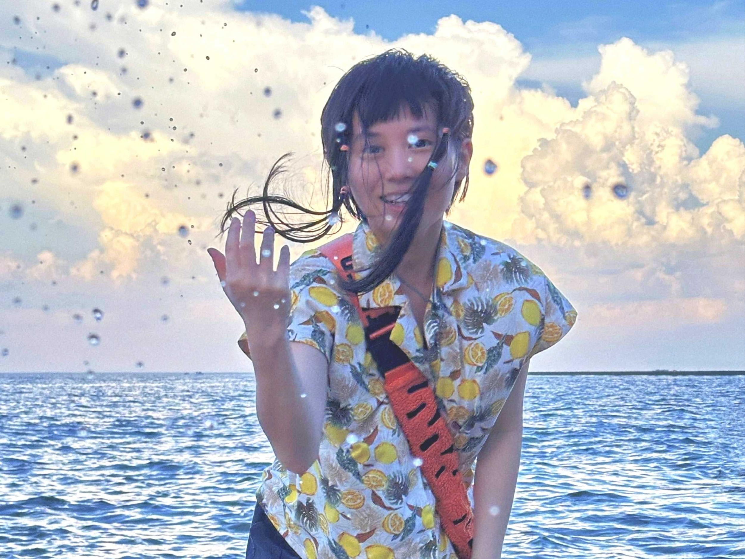 Yusia Xiao stands in front of the sea.