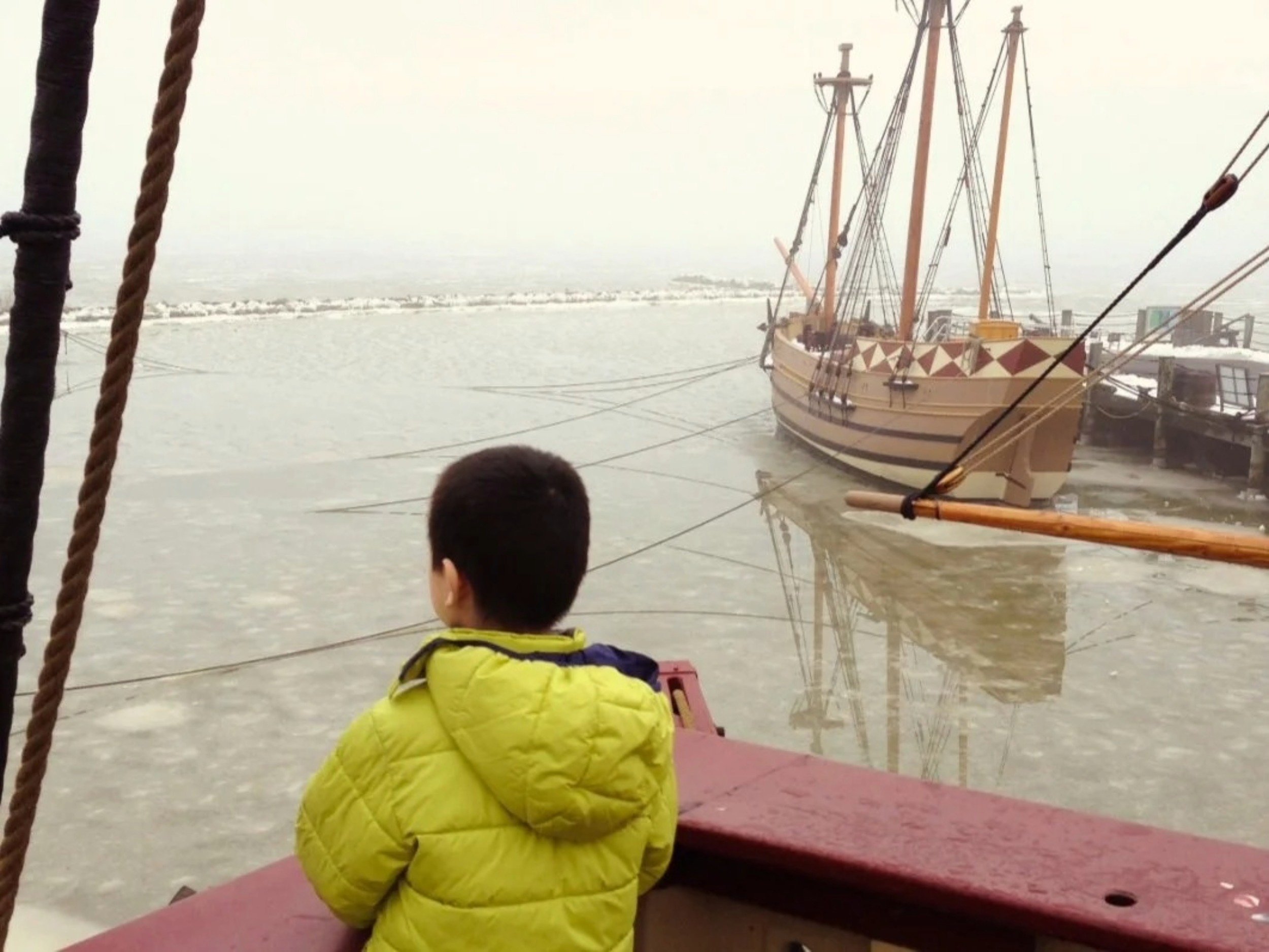 Young Ian Chen stands at the edge of a harbored ship.