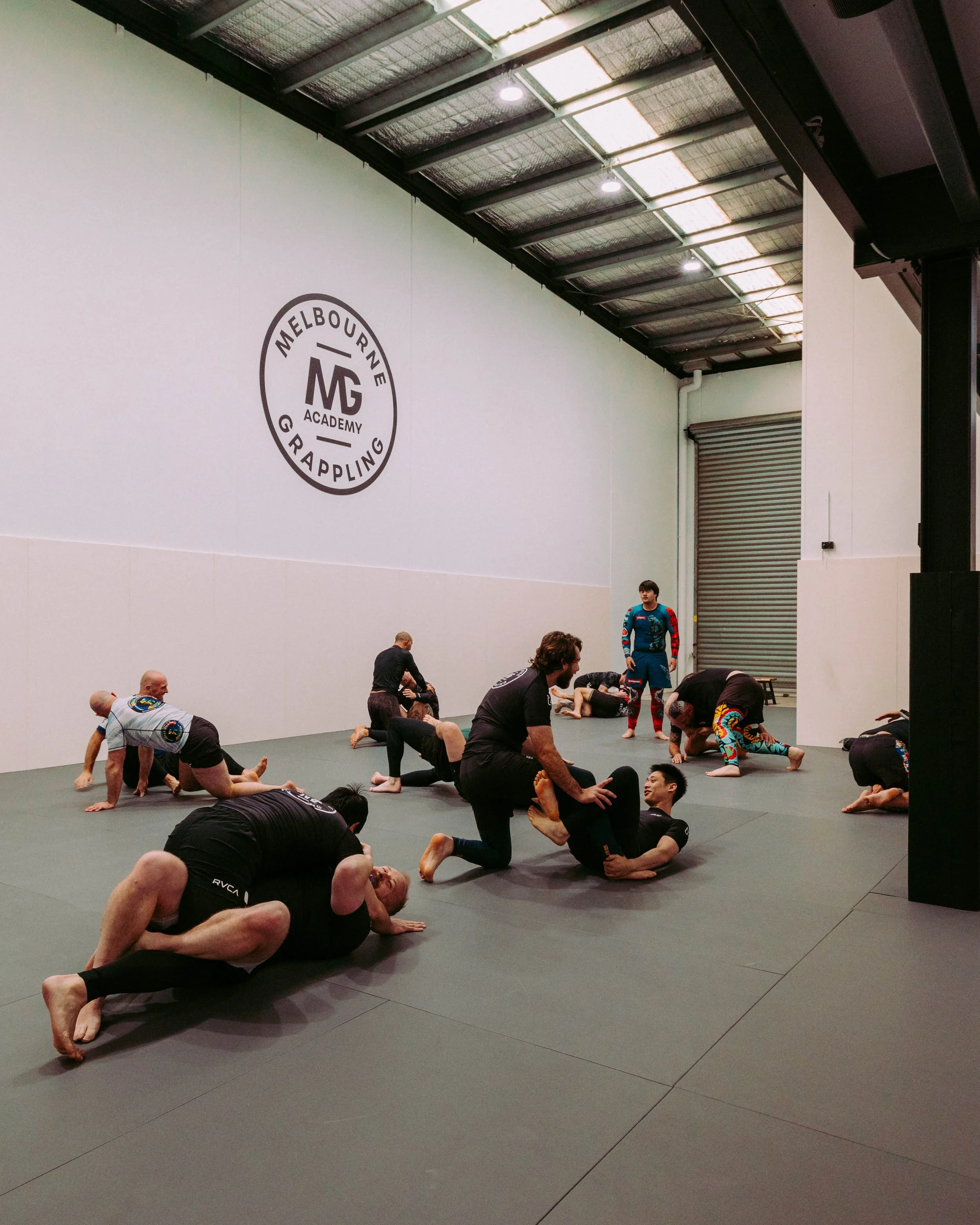 Group of members rolling on the mats during an open mat session at Melbourne Grappling Academy