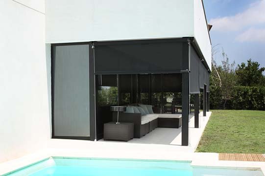 Outdoor covered patio with a seating area, house exterior, and swimming pool in the foreground.