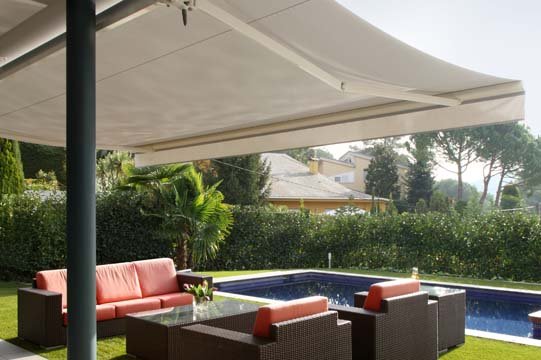 Outdoor patio area with a seating area, a small pool, and a large shade sail overhead.